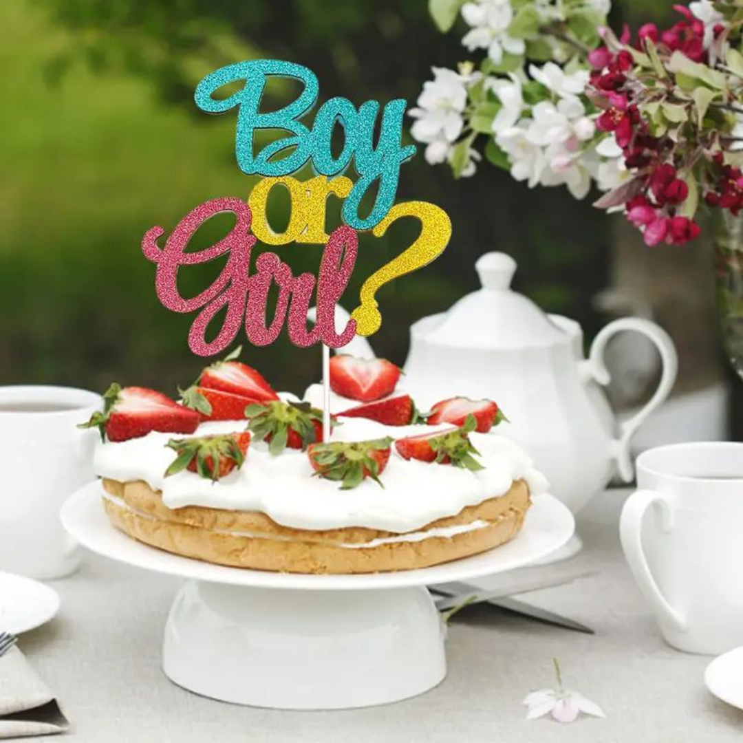 Boy or Girl? cake topper on a strawberry-topped cake for gender reveal party